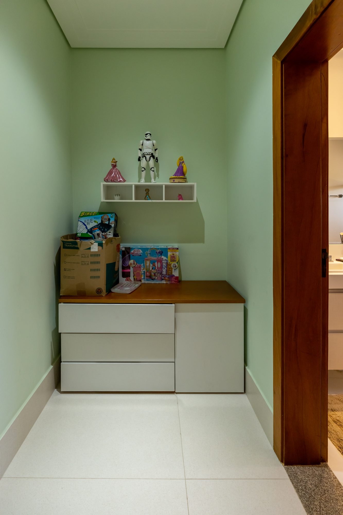 Hall das suítes com gaveteiro, nicho decorativo e brinquedos