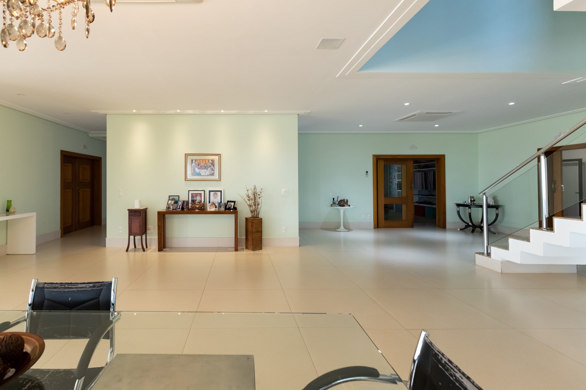 Hall social amplo com lustre de cristal e escada de mármore