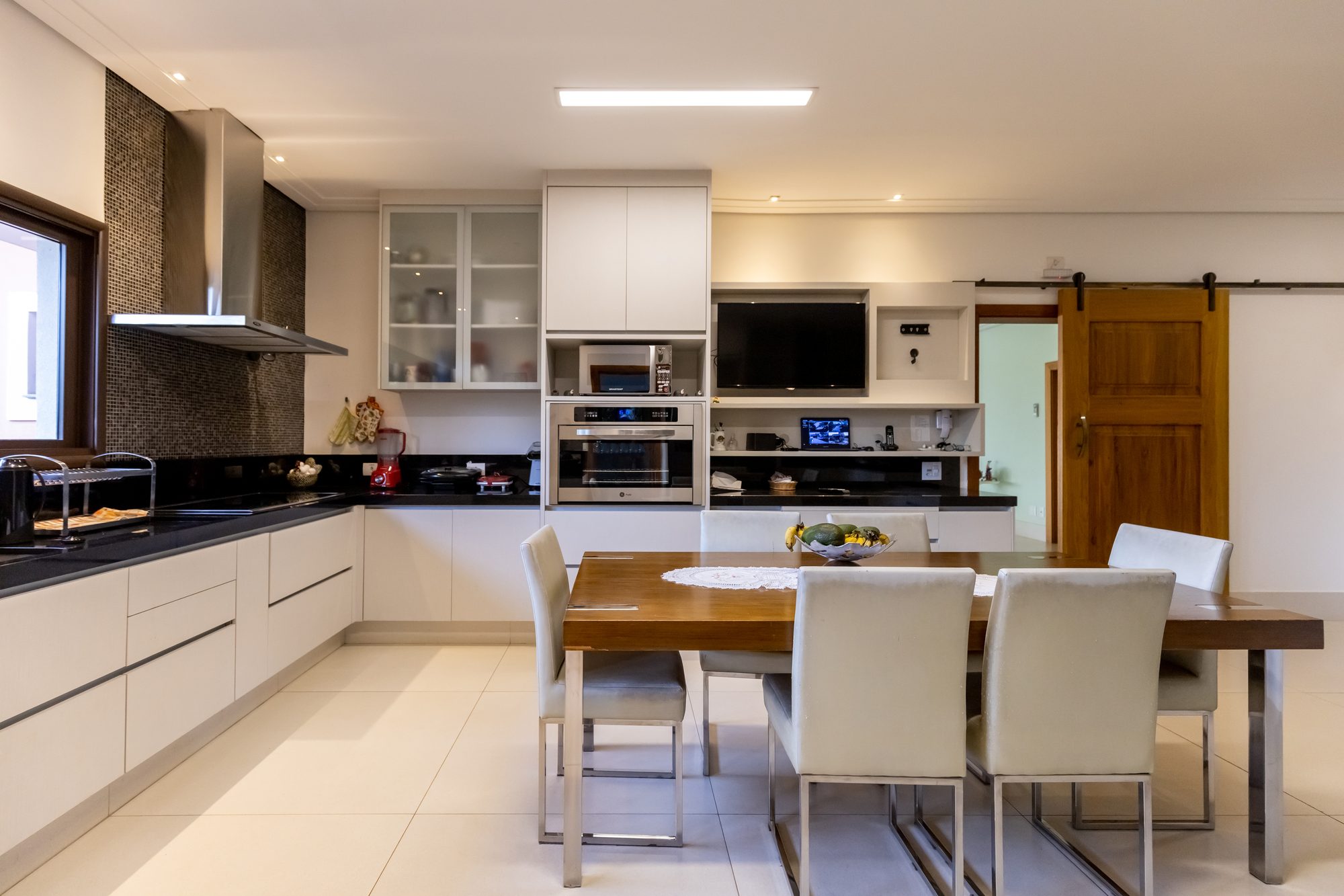 Cozinha com forno embutido, coifa e TV