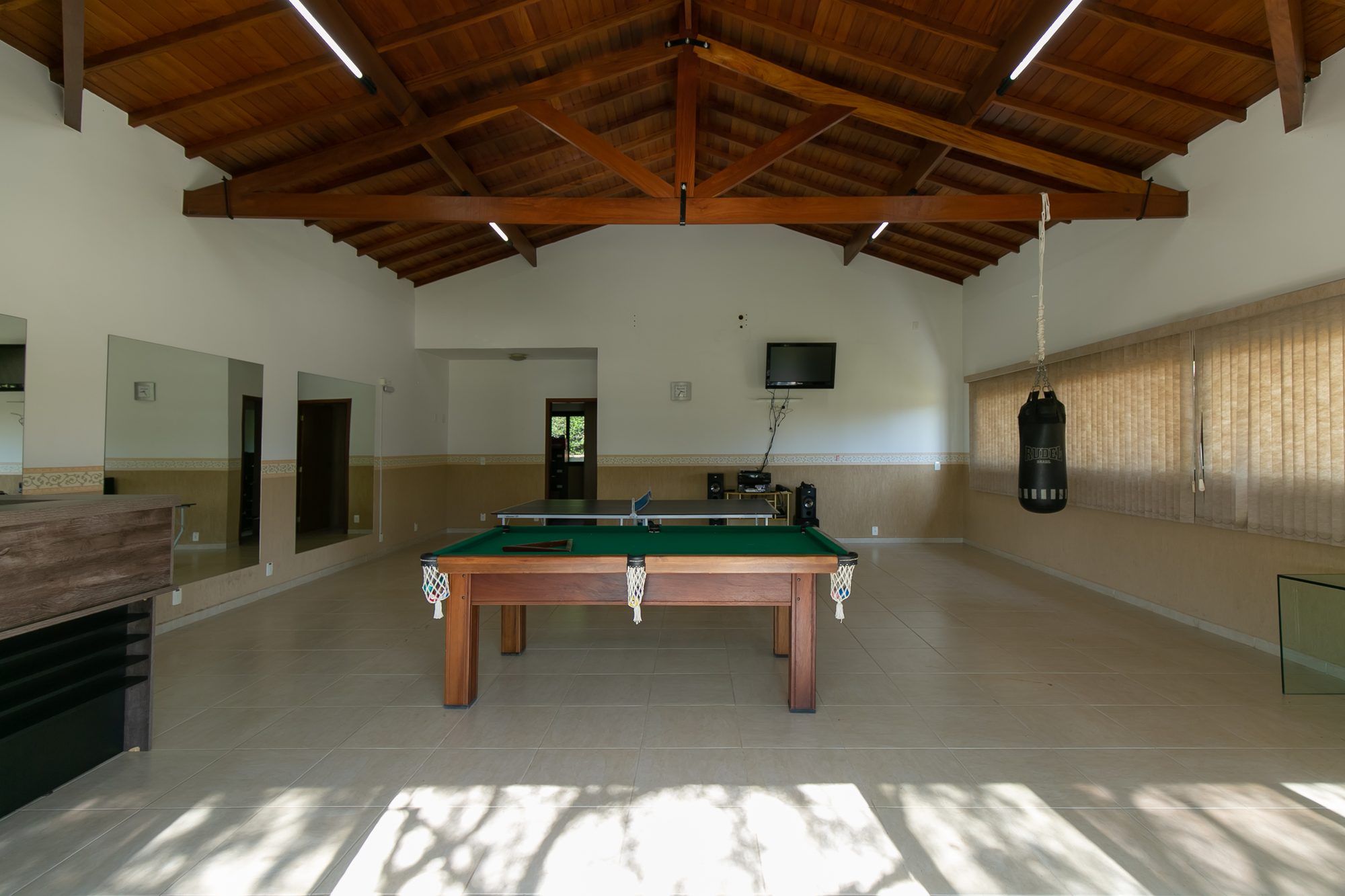 Salão de jogos com sinuca, ping-pong e saco de pancada