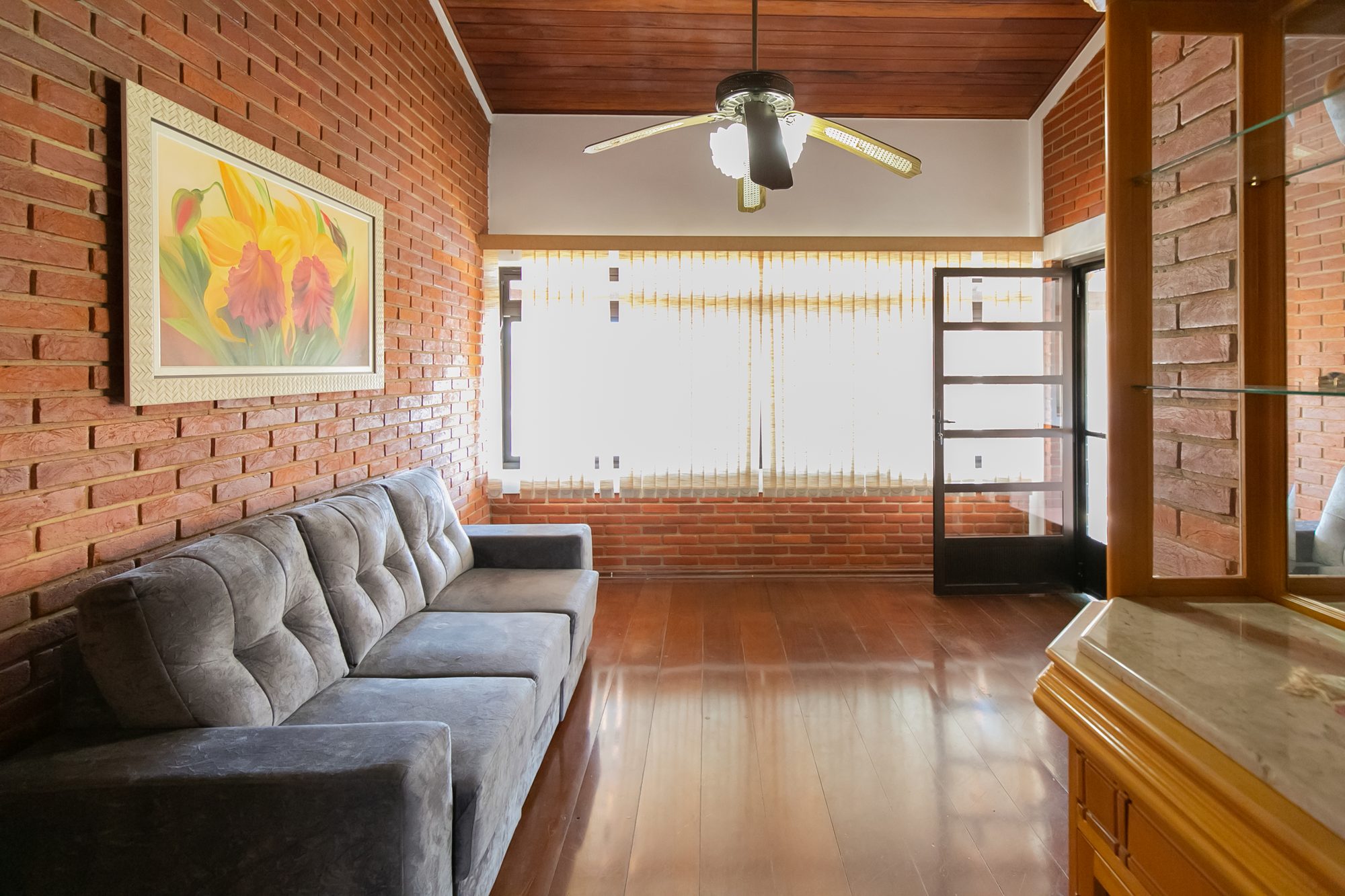 Sala de TV com parede de tijolos e sofá
