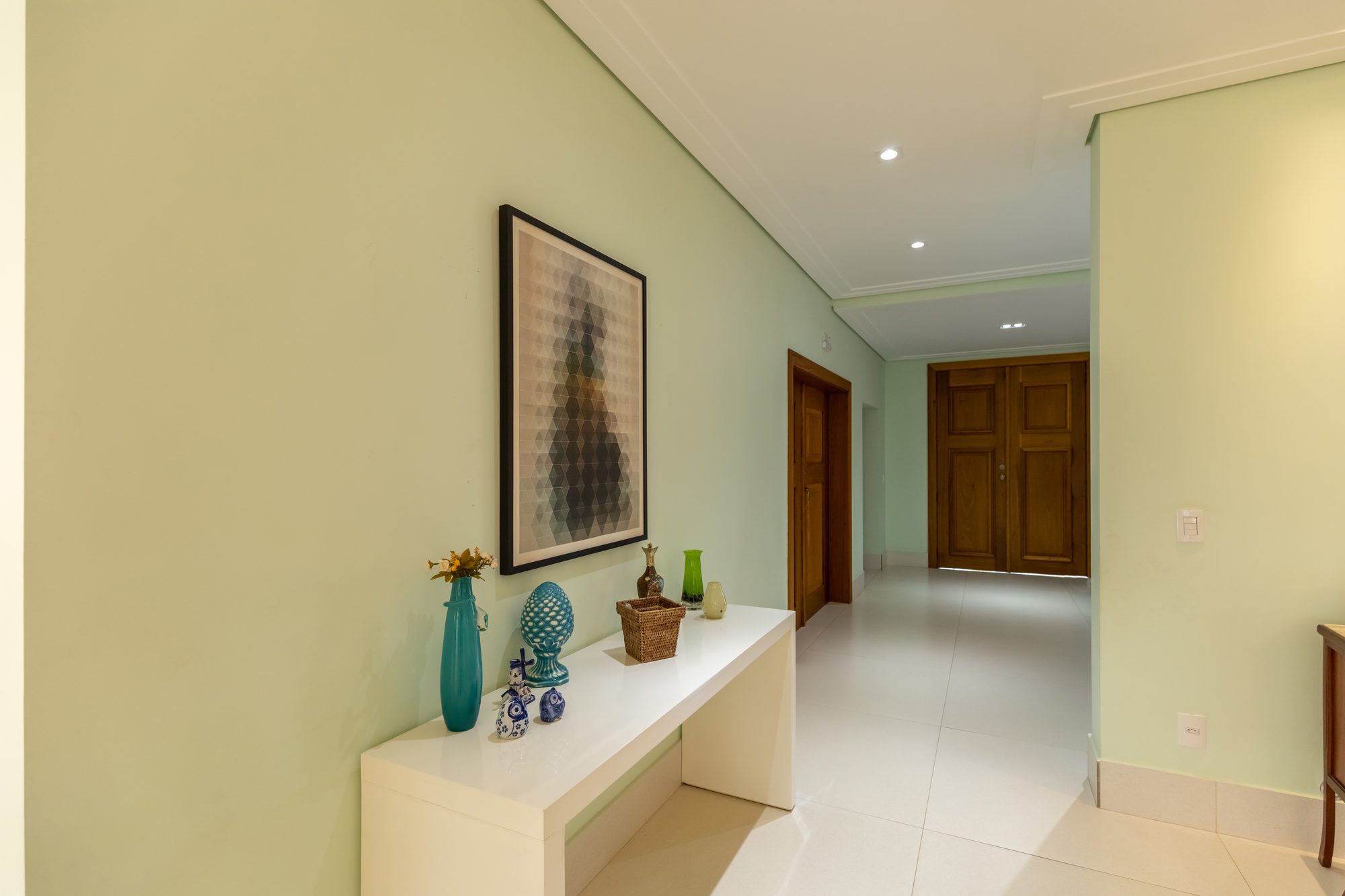 Hall de entrada com aparador branco e quadro geométrico