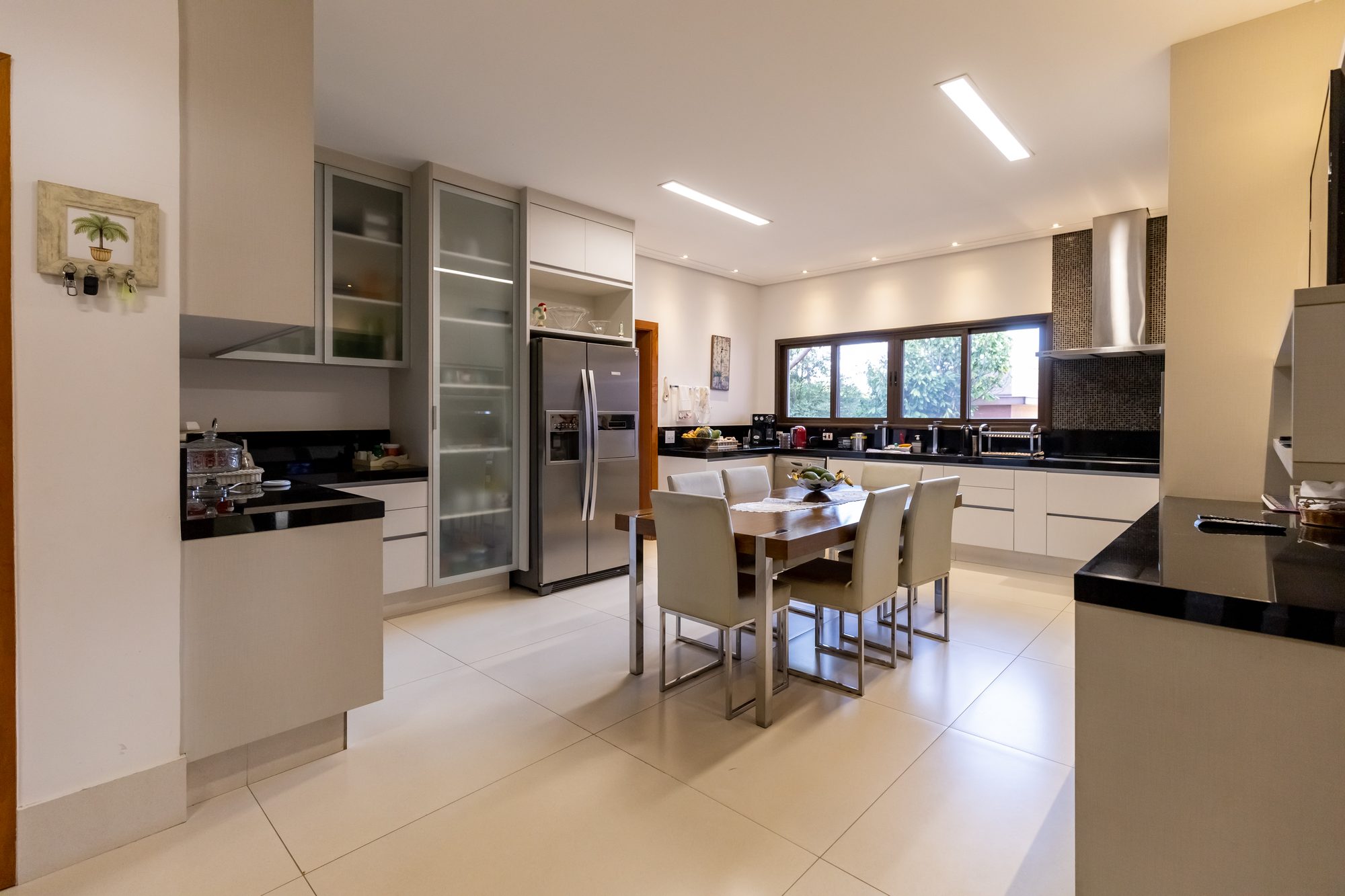 Outro ângulo da cozinha com armários e mesa para seis