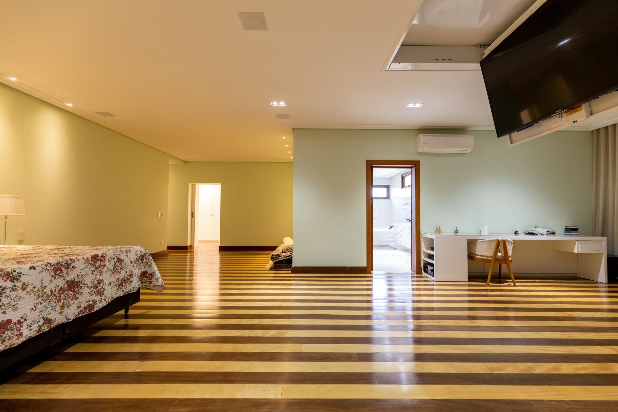 Suíte master com cama de casal, penteadeira e acesso ao banheiro com banheira